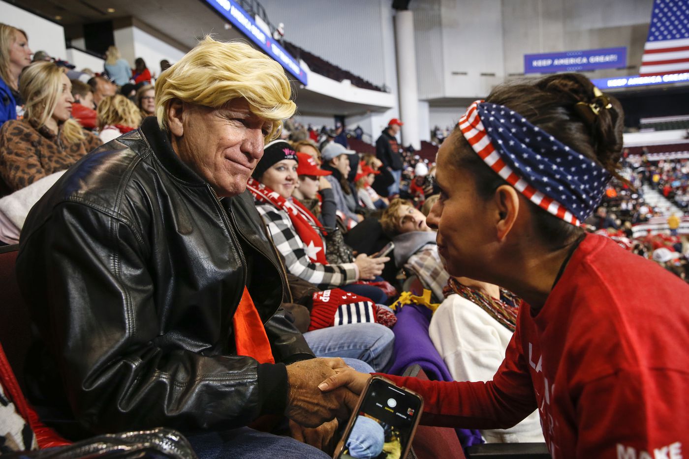 Martha Doss greets Eddie Barnes of Haughton, La., dressed in a Trump wig at a rally to reelect President Donald Trump in Bossier City.