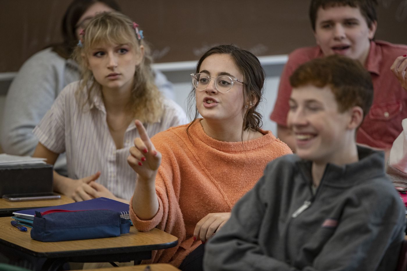 Grace Amico (center) makes her case about climate change to Trump supporter Nick Stanco, the student body president.