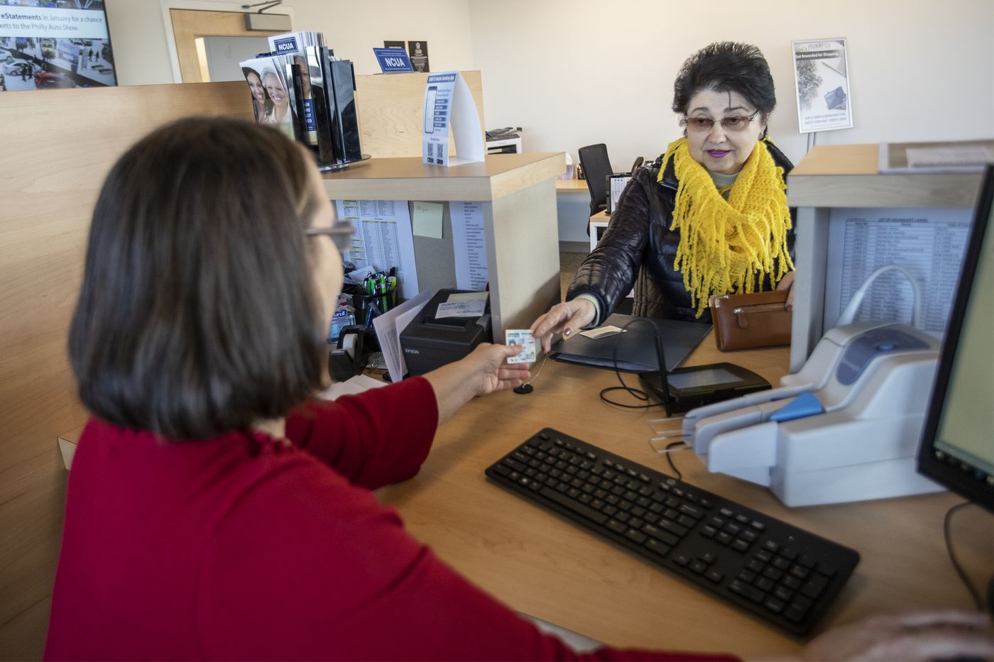 Alla Fisun, right, who has been a customer of the Ukrainian Selfreliance Credit Union for 27 years, works with head teller Tatyana Mariyanich, left, in the customer area of the Feasterville location.
