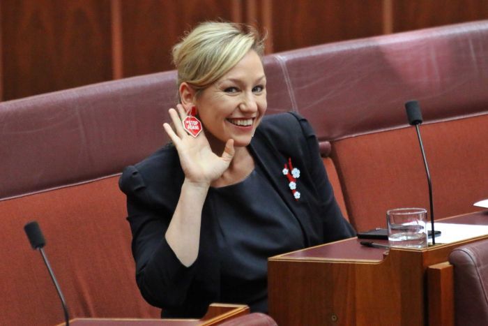 Larissa Waters holds her hand to her ear showing off "stop Adani" earrings