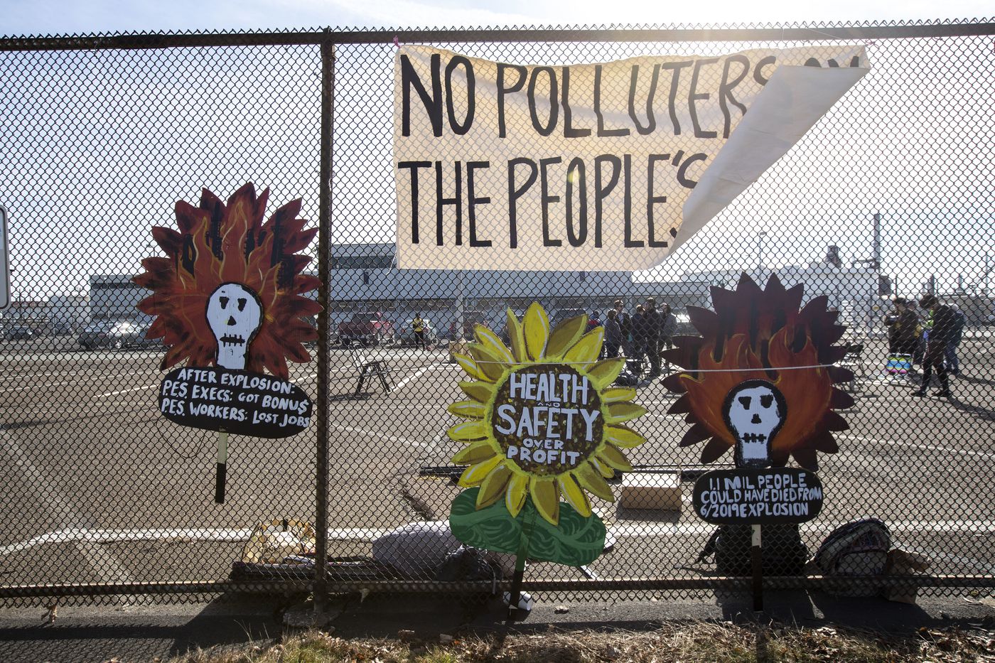 Signs decorate a fence outside the Philadelphia Energy Solutions refinery in Philadelphia last week. Philly Thrive organized a 10-hour occupation against reopening it as an oil-processing facility.
