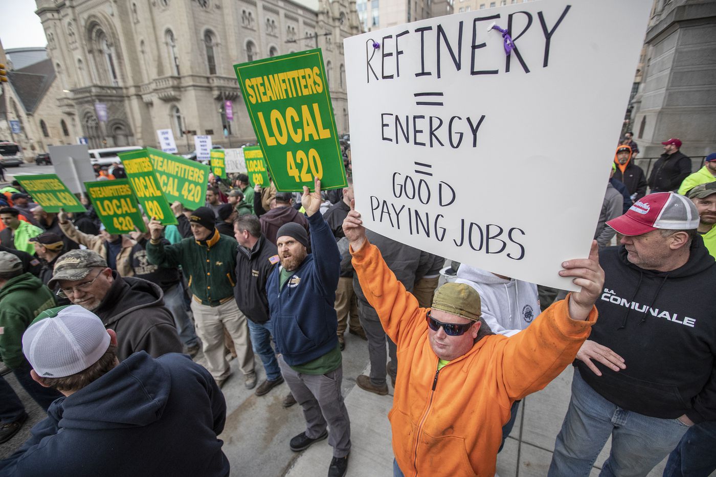 Mike Carney (right) of Steamfitters Local 420, rallies with fellow building trade union members in front of City Hall last month in support of saving the bankrupt Philadelphia Energy Solutions refinery.