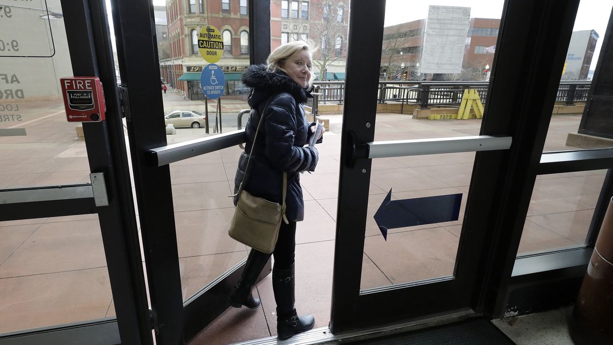 In this Thursday, Jan. 16, 2020 photo Jo Goode, city hall reporter for The Herald News, exits Fall River City Hall, in Fall River, Mass. Goode's paper has already laid off most of its reporting staff and recently announced plans to sell its historic downtown office to trim costs. (AP Photo/Steven Senne)