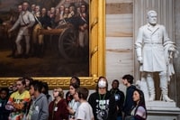 Image: A tour group, with one member wearing a mask, tours the Capitol Rotunda on March 12 before tours were canceled for the coronavirus pandemic.