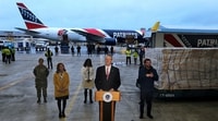 Image: Massachusetts Gov. Charlie Baker (R) at Logan Airport on April 2 after a plane owned by the New England Patriots arrived with a shipment of 1.2 million N95 masks from China for use in Massachusetts and New York.