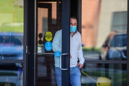 Michael McLachlan, 46, of Plymouth wears a surgical mask as he exits his building on Wednesday, May 13, 2020. McLachlan says that he wears a mask, because if essential workers can make the sacrifice and wear a mask so could he. 