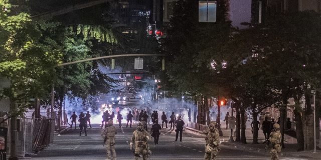 Authorities gather in the street amid protests in Portland. Ore. 