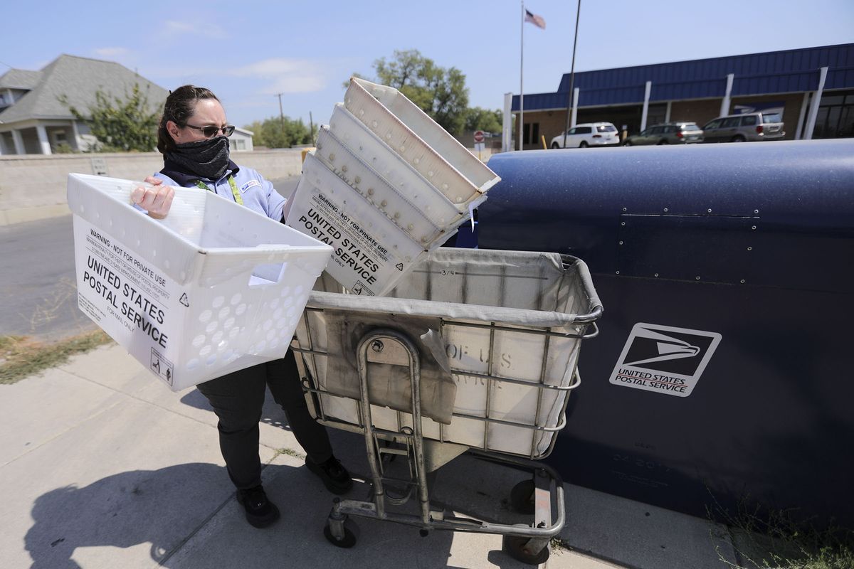 Kristina Evans, U.S. Postal Service sales service associate, empties mail out of collection boxes outside of the post office in South Salt Lake on Tuesday, Aug. 18, 2020. Mail is emptied out of the boxes three times a day.