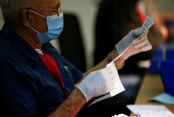 An elections worker inspected a ballot in Washington State this summer. Voting by mail, which in Washington is universal, has surged in many other states because of the pandemic.