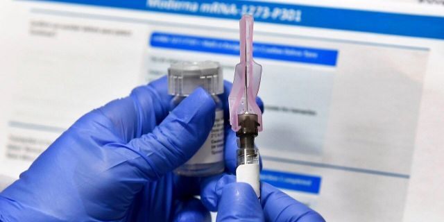 A nurse prepares a shot as a study of a possible COVID-19 vaccine, developed by the National Institutes of Health and Moderna Inc., gets underway in Binghamton, N.Y. (AP Photo/Hans Pennink)