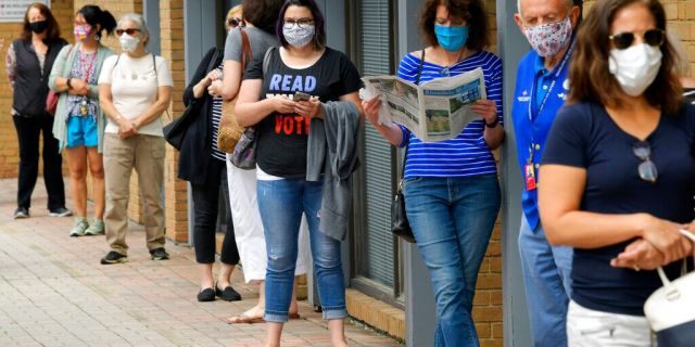 In this Sept. 18 photo, Alexandria residents wait in a socially distance line to cast their ballots for the November presidential election on first day of early voting in Virginia, at the Voter Registration Office in Alexandria, Va. (John McDonnell/The Washington Post via AP, File)