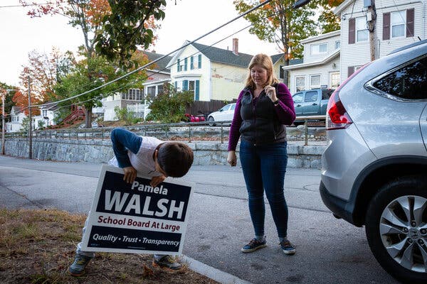 Pamela Walsh and her 7-year-old son, Luke, installed campaign signs in Concord, N.H., where Ms. Walsh is running for the school board.