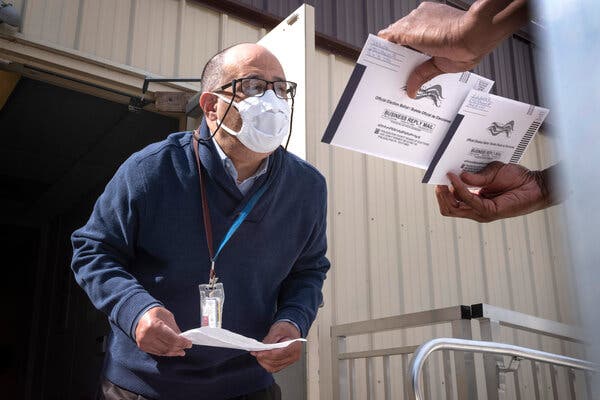 An employee of the Philadelphia Commissioners Office examines ballots at a satellite election office at Overbrook High School. The city of Philadelphia has opened several satellite election offices and more are slated to open in the coming weeks where voters can drop off their mail in ballots before Election Day.