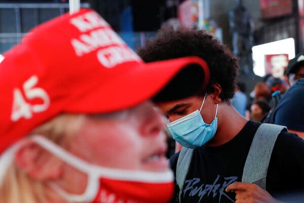 A supporter of U.S. President Donald Trump is seen as a demonstrator wearing a face mask at Times Square in New York.